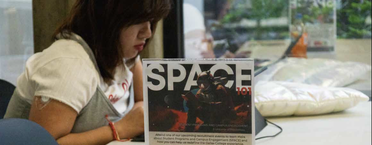 Dallas College student Phuong Nguyen studies next to a SPACE recruitment flyer.